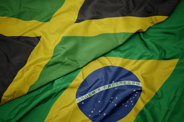 waving colorful flag of brazil and national flag of jamaica.