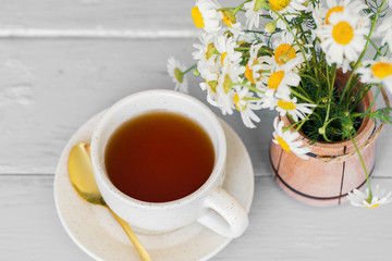 cup of herbal chamomile tea with fresh daisy flowers on wooden background. doctor treatment and prevention of immune concept, medicine - folk, alternative, complementary, traditional medicine