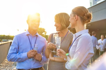 Business colleagues holding wineglasses during success party at terrace