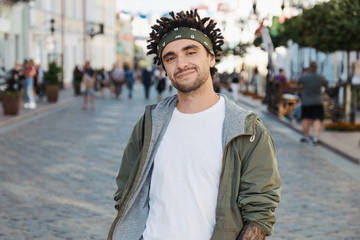 Confident guy with dreadlocks hairstyle, close up portrait, street photo, urban style. Young...
