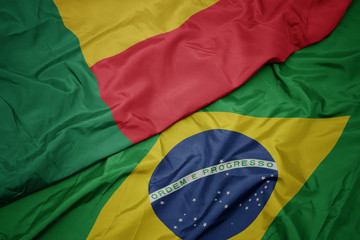 waving colorful flag of brazil and national flag of benin.
