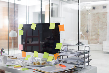 Photo of messy computer desk of young professional at office