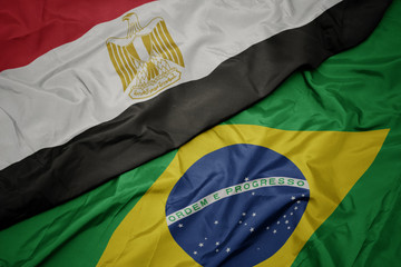 waving colorful flag of brazil and national flag of egypt .