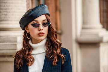 Outdoor close up autumn portrait of young elegant fashionable woman wearing trendy leather beret,...