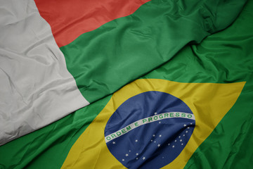 waving colorful flag of brazil and national flag of madagascar.