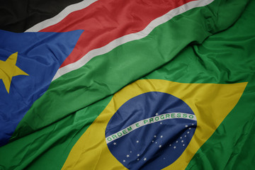 waving colorful flag of brazil and national flag of south sudan.