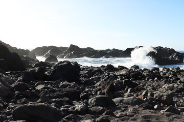 Waving crashing into a rock on a beach in Los Gigantes, Spain