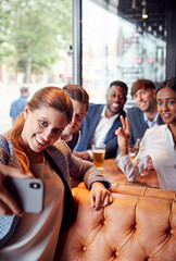 Obraz premium Group Of Business Colleagues Posing For Selfie In Bar After Work
