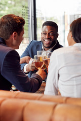 Group Of Business Colleagues Making A Toast As They Meet For Drinks And Socialize In Bar After Work