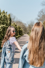 Fototapeta premium Friendship day. Lifestyle image of best friend girls in spring summer city street. Two Teenage girls having fun in the park