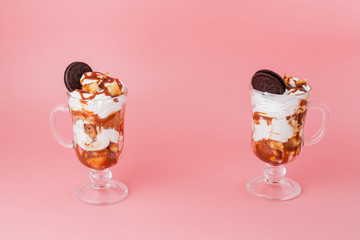 Sweet dessert in glass with biscuit and whipped cream on pink bsckground, selective focus and blank space