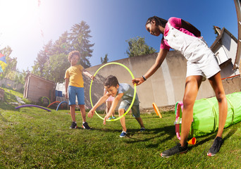 Boy jump through hula hoop ring on playground © Sergey Novikov