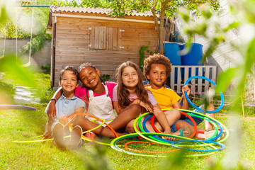 Group of children sit together with hula hoops © Sergey Novikov