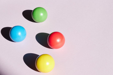 Four colored balls on a light background with hard shadows. abstract background for design. Copy space geometry