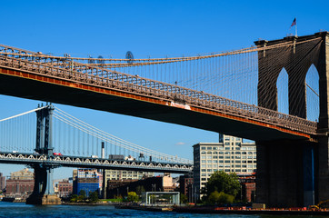 Naklejka premium NEW YORK, NY - Historic Brooklyn Bridge and New York City seen from Brooklyn Bridge Park. Spanning the East River, this 1883 bridge connects Manhattan and Brooklyn.