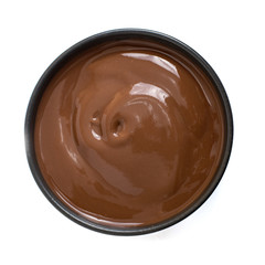 Chocolate pudding in dark bowl isolated on white background. Top view