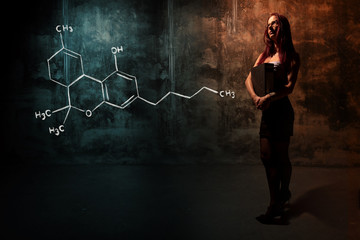 Sexy girl or secretary or female student presenting handdrawn chemical formula of THC