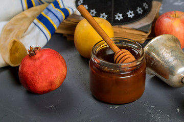 Honey on the pomegranate and apples. Jewishs new year Rosh Ha Shana torah book, kippah yamolka and...