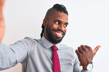 African american businessman make selfie by camera over isolated white background pointing and showing with thumb up to the side with happy face smiling