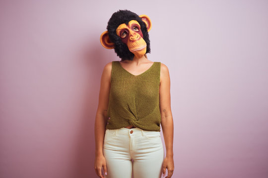 Woman standing wearing t-shirt and monkey mask
