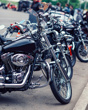 Lots of mopeds and motorbikes parked on the street.