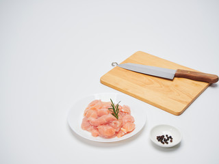 Fresh chicken tenderloin with wooden board, knife.