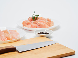 Fresh chicken tenderloin with wooden board, knife.