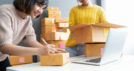 Startup small business owner working with computer at workplace. Freelance two woman seller check...