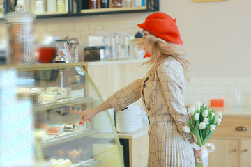 girl with a bouquet of flowers in a cafe / beautiful showcase, diet, happiness, mood