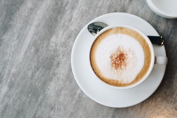 Hot coffee and hot tea place on the marble table in early morning with copyspace, white cup and silver spoon.