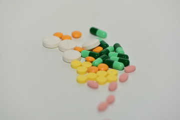 Pills, capsules, antibiotics, various colors on a white background