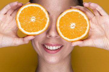 Cute young woman holding orange slices