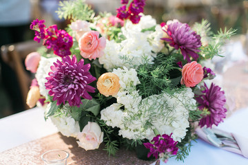 Modern colorful wedding flower table arrangement, pink, yellow, purple, and white flowers, wedding reception decor