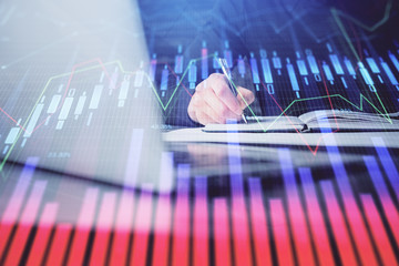 Double exposure of businessman with laptop and stock market forex chart.