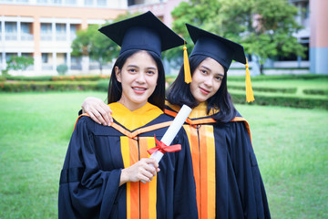 Young Asian woman university graduates celebrate with joyouse and happiness with friends after receiving university degree certificate in commencement ceremony.