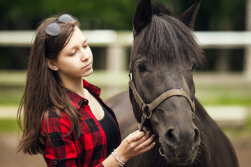 Obraz premium Young girl with the black horse
