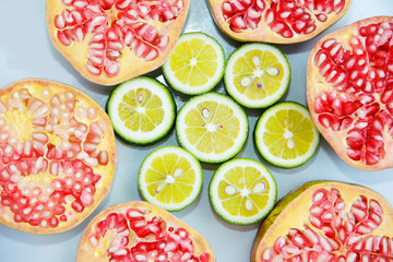 slices of red natural pomegranate and slices of yellow lime lemon