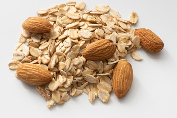 Pile of oatmeal and almonds. Isolated. On white background.