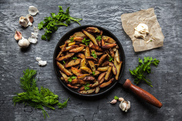 Fried potatoes on a dark background. Food