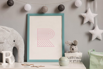 Stylish scandinavian childroom with blue mock up poster frame, toys, boxes, plush elephant and rabbit. Hanigng stars and cotton balls on the gray background wall. Cozy home decor. White shelf concept.