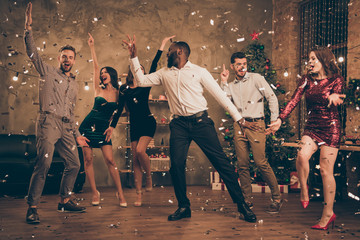 Full length photo of cheerful multinational buddies dance enjoy christmas party x-mas holidays in...