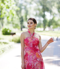 Portrait of sensual young woman in stylish dress walking in city park. Lifestyle concept. Close-up
