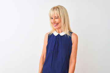 Middle age woman wearing elegant blue dress standing over isolated white background winking looking...