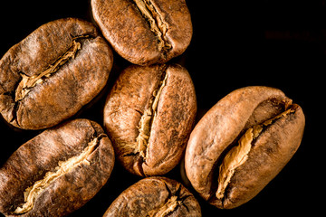 Macro close up of coffee beans on a black background