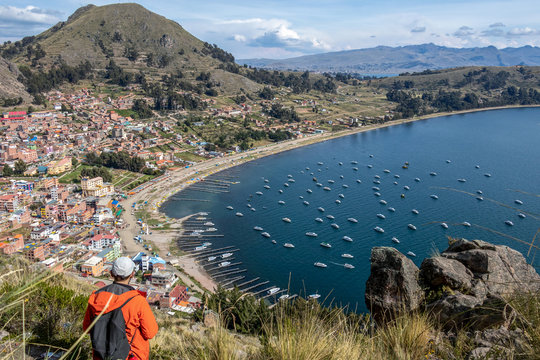 Young tourist man back view. Caucasian male traveler admiring Titicaca lake landscape in Copacabana, Bolivia