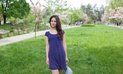 Young happy woman smiling enjoying spring day.Sakura tree blooming.Soft and tender. Gorgeous flower and female beauty. Woman in spring flower bloom