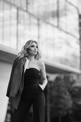 Fashion portrait of a young woman in a black suit. Black and white image