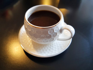 espresso coffee in white cap on black table