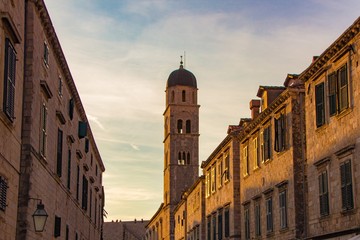 Scenic evening view at the bell tower of the Franciscan church and monastery on famous historic Stradun street in old town of Dubrovnik, Croatia.