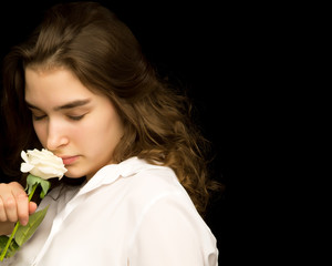 Naklejka premium Little girl with a white flower on a black background.